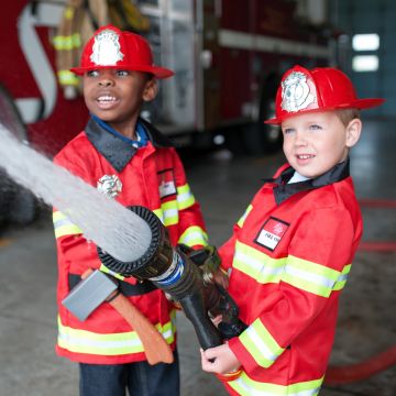 Great Pretenders FEUERWEHR KOSTÜM Mantel mit Helm, Axt, Feuerlöscher & Abzeichen (5-6 Jahre)